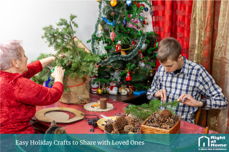 An older woman and her young grandson sit together under a decorated Christmas tree, smiling as they craft homemade wreaths using greenery and ribbons. The scene captures a warm, festive moment of creativity and family connection.