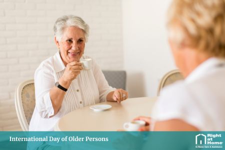 Older person drinking coffee with friend enjoying International Day of Older Persons and staying social