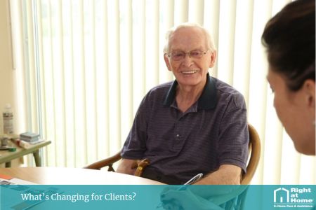 A Right at Home care worker sitting at a kitchen table with an older Australian client, discussing their new Support at Home care plan and funding options in a friendly home environment.